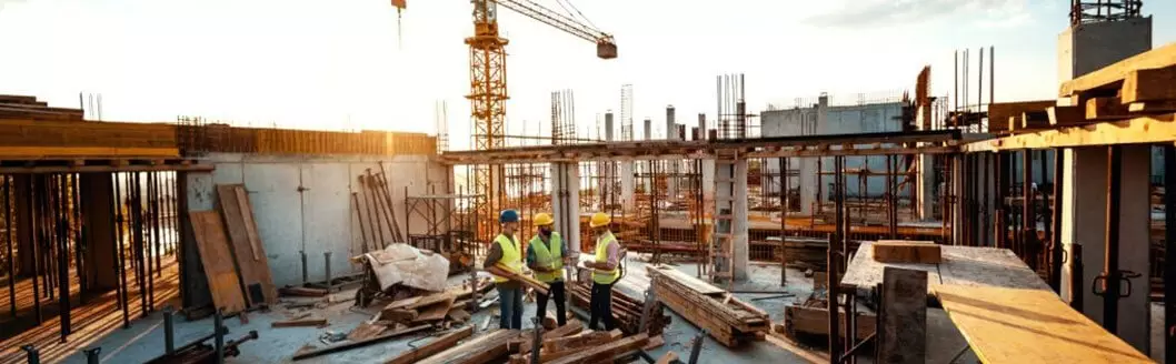 Empresa de construcción desarrollando un edificio con grúas y columnas