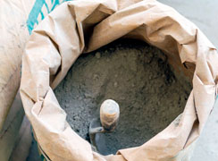 Bulto de cemento mortero abierto con cuchara adentro