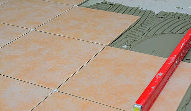 Proceso de pegado de azulejo en piso