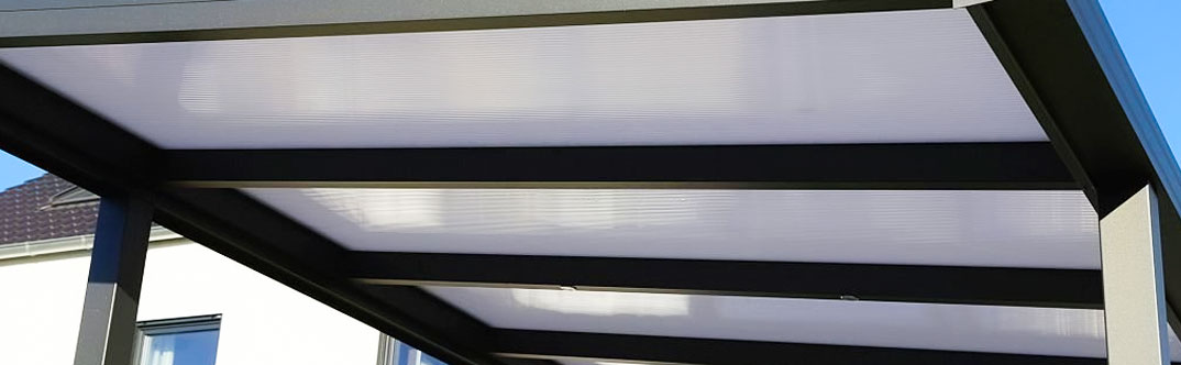 Acercamiento al techo de una cochera con perfiles y lámina lisa pintro de color blanco