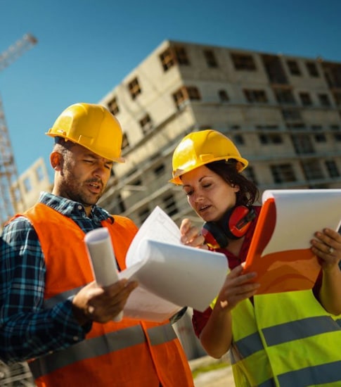 Trabajadores del sector de la construcción revisando los planos de una obra