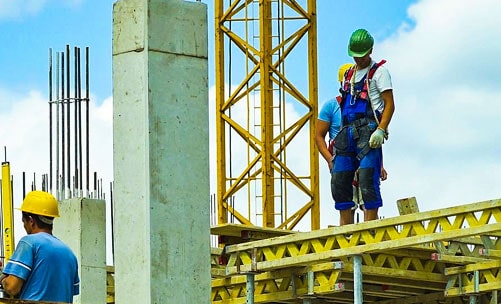 Trabajadores de la construcción portando equipo de seguridad en una obra