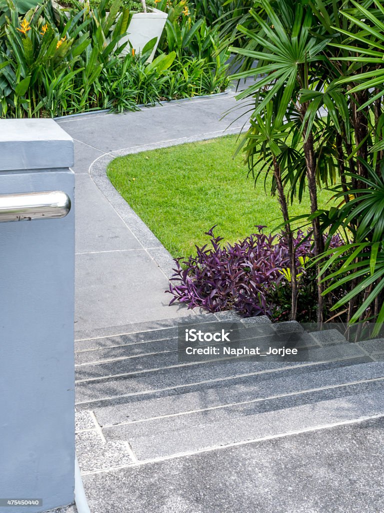 Escalera de concreto con descanso para exterior en medio de un jardín de gran tamaño