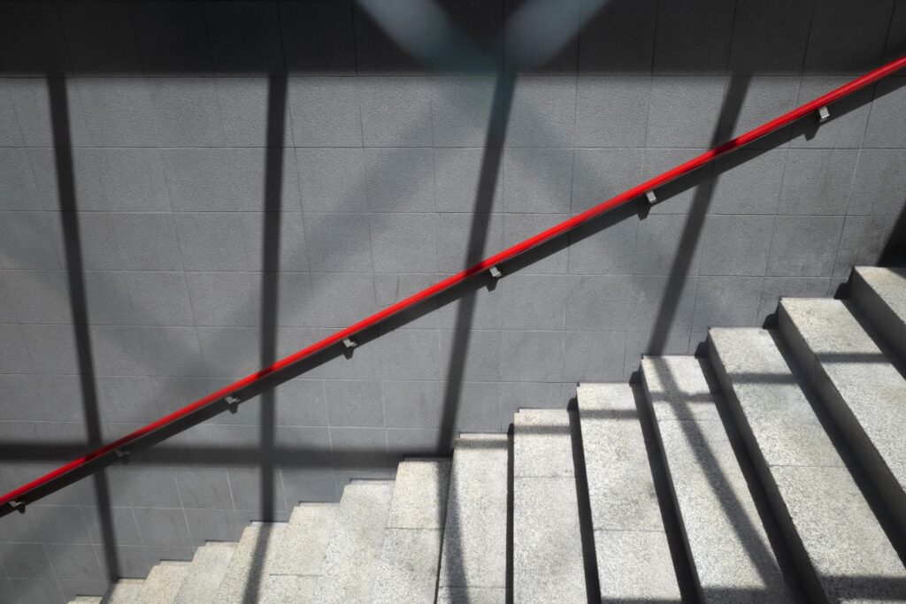 Vista lateral de una escalera de concreto moderna complementada con un barandal de acero