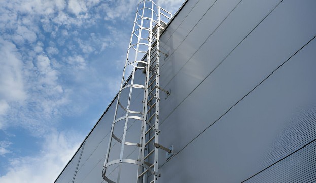 Escalera marina de acero en costado de almacén