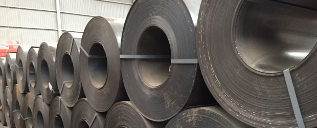 Conjunto de rollos de lámina negra apilada en bodega